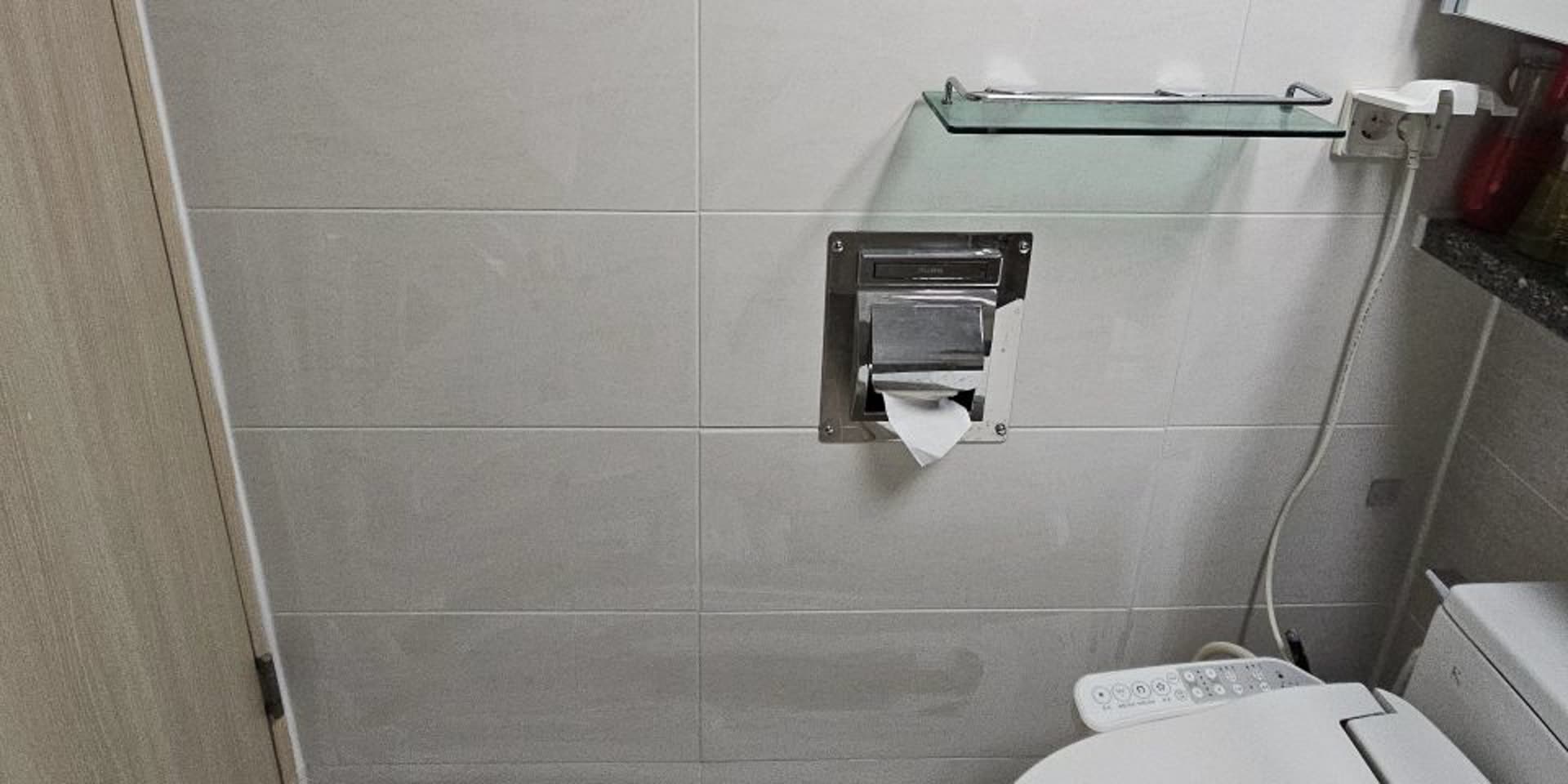 타일교체를 마친 화장실 벽면의 유리 선반과 휴지걸이 주변 모습